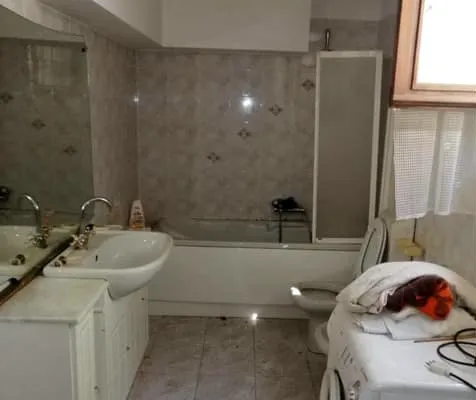 Il bagno prima dei lavori: vasca, sanitari e piastrelle datate